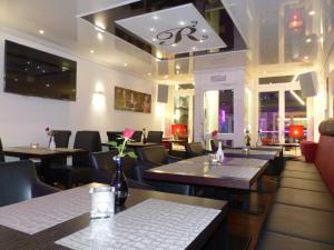 Un restaurante con mesas y sillas y un techo. en Aparthotel C'est la vie, en Saarlouis
