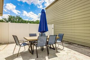 a table with a blue umbrella and chairs at Wood Circle Art Deco Home near Disney and I4 in Lakeland