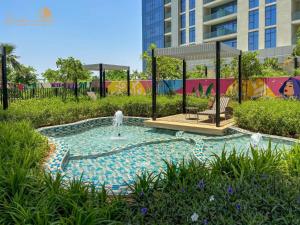 a swimming pool with a fountain in a park at Elegant Sunset View 3BHK 7pax in Dubai