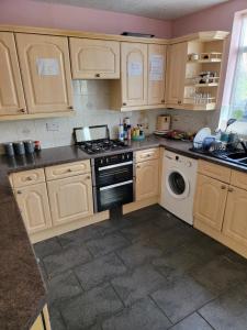a kitchen with a stove and a dishwasher at Abakwa yellow in Kingsthorpe