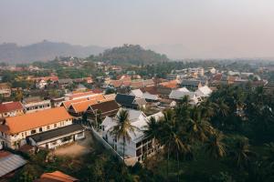an aerial view of a town with buildings and palm trees at Asoca Hotel Luang Prabang in Luang Prabang