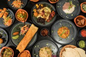 a table topped with plates of food and bowls of food at Surfescape Sri Lanka in Midigama East