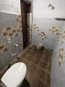 a bathroom with a toilet in a room with bugs on the walls at RS Homestay Puri in Puri