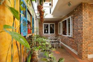 a brick building with a patio with chairs and plants at Loankim Homestay in Hue