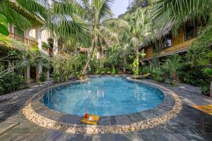 a swimming pool in a resort with palm trees at Trang An Aroma Ecolodge Ninh Binh in Ninh Binh