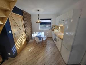 a small kitchen with a table and a refrigerator at Marina Kociewska in Ocypel