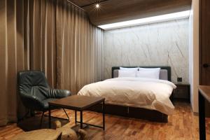 a bedroom with a bed and a chair and a table at Hotel CL in Hanam