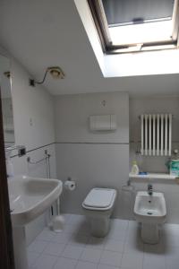 ein Badezimmer mit einem Waschbecken, einem WC und einem Dachfenster in der Unterkunft Anna Rita B&B in Moie