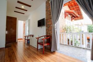a living room with a table and chairs and a balcony at Loankim Homestay in Hue
