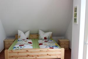 1 dormitorio con 2 camas y 2 mesitas de noche en Ostseepension TonArt, en Mechelsdorf