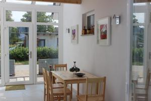 a dining room with a wooden table and chairs at Ostseepension TonArt in Mechelsdorf