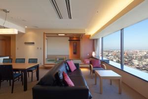 a living room with a couch and a table at Kanazawa Tokyu Hotel in Kanazawa