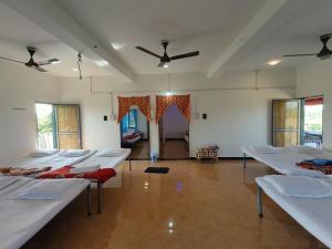 a room with a bunch of beds in it at Gokul farm house in Sasan Gir