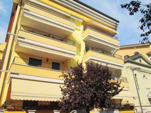 a yellow building with a tree in front of it at Casa Sonneninsel in Grado