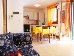 a living room with a couch and a kitchen with a table at Casa Sonneninsel in Grado