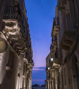 an alley between two buildings with a blue sky at Archè in Syracuse