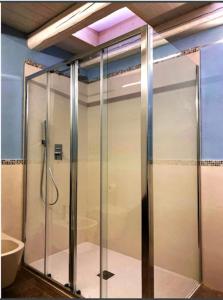 a glass shower in a bathroom with a tub at Archè in Syracuse