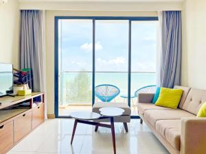 a living room with a couch and a view of the ocean at TimurBay Seafront Residence Kuantan in Kuantan
