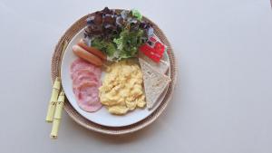 a plate of food with meat and vegetables and bread at The Green Season Resort in Ban Mae Kham Lang Wat