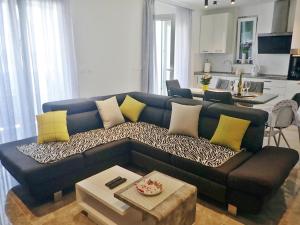 a living room with a blue couch with yellow pillows at Holiday Home Maslenica with Pool near Beach in Maslenica