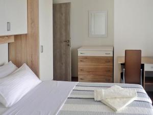 a bedroom with a white bed with a desk and a chair at Holiday Home Maslenica with Pool near Beach in Maslenica +36 photos