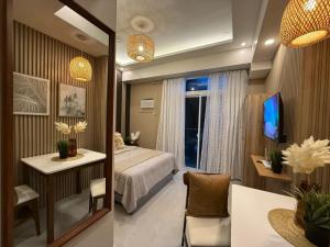 セブシティにあるMivela Suites Charming Staycation Cebu with Netflixのベッドと鏡のあるホテルの部屋