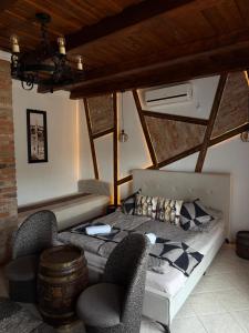 a bedroom with a bed and chairs in a room at Egri Leányka Vendégház in Eger