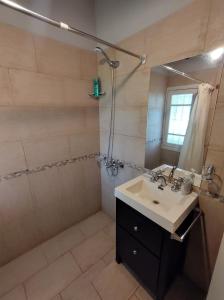 ein Badezimmer mit Waschbecken und Dusche in der Unterkunft La Casa del Molino in Sierra de la Ventana