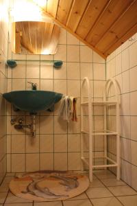 ein Badezimmer mit einem grünen Waschbecken an einer gefliesten Wand in der Unterkunft Binderhof in Weisspriach