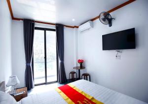 a bedroom with a bed and a flat screen tv at Khách sạn Tiến Đạt in Mèo Vạc