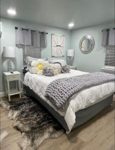 a bedroom with a large bed and a rug at Tiny Home in Town-Hot Tub - Privacy Fence - Fire Pit - Kids Play Area & 15 minutes to the Bogue Chitto State Park in Franklinton
