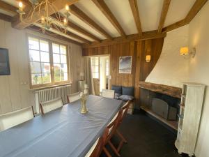 a dining room with a table and a fireplace at Le Moulin in Saint-Pair-sur-Mer