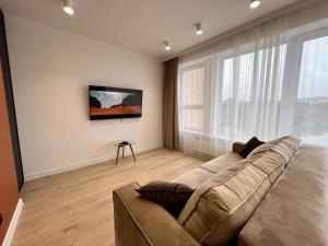 a living room with a couch and a large window at Panoramic Lake View in Chişinău