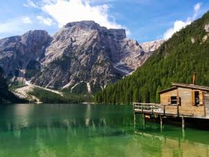 a cabin on a lake in front of a mountain at Comfortable house - garden and parking in Farra di Soligo