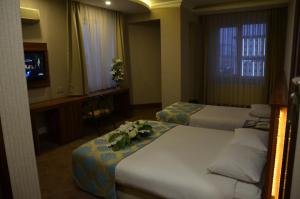 a hotel room with two beds and a television at Ayintap Hotel in Gaziantep