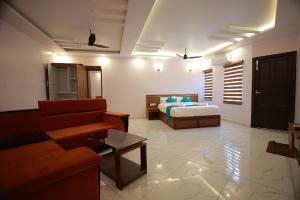 a living room with a bed and a couch at TTS Residency in Kaliyal