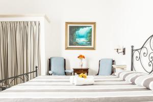a hotel room with a bed and blue chairs at Palazzo Angelelli in Gallipoli