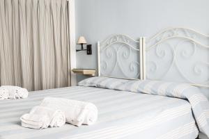 a bedroom with a white bed with towels on it at Palazzo Angelelli in Gallipoli