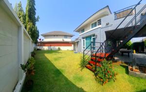 a backyard of a house with a yard with flowers at A,B house Chiangmai in Chiang Mai