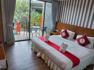 a bedroom with a large bed with red and white pillows at Ohophuket in Phuket
