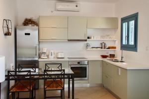 a kitchen with a table and chairs and a refrigerator at Sunset Vista in Kamári +27 photos