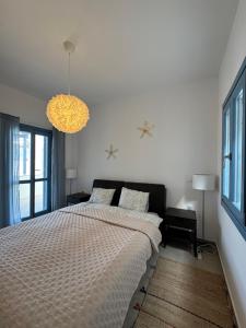a bedroom with a large bed and a chandelier at Sunset Vista in Kamári