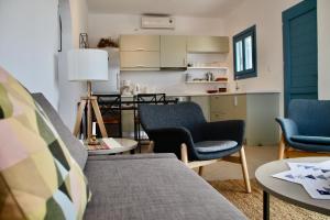 a living room with a couch and chairs and a kitchen at Sunset Vista in Kamári
