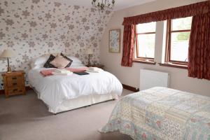 Un dormitorio con dos camas y una ventana. en Home Farm Bed and Breakfast, en Muir of Ord