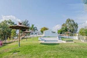 un parque con banco y sombrilla en Finca Buenavista, en Chilches