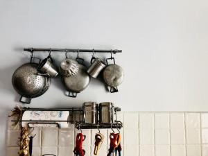 a bunch of pots and pans hanging on a wall at Downtown Grandama Home della Cassatella - Air Conditioner&wifi in Castellammare del Golfo