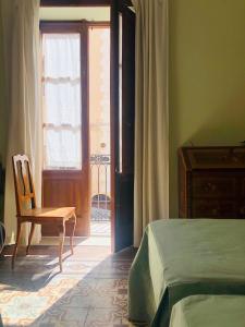 a bedroom with a bed and a chair and a window at Downtown Grandama Home della Cassatella - Air Conditioner&wifi in Castellammare del Golfo