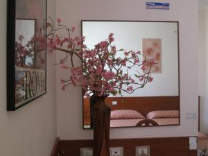 a vase filled with pink flowers in a room at Hotel Katty in Rome