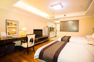 a hotel room with a desk and a television at The Legend HOME Service Apartment in Guangzhou