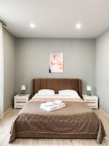 a bedroom with a large bed with two night stands at Apartments Domovik Стильна квартира, Миру 11 c кв 2 in Mukacheve